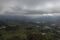 Colombian countryside landscape with grey big clouds, sunbeams and mountain range