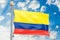 Colombian flag waving in blue cloudy sky, 3D rendering