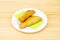 Colombian yellow corn empanadas stuffed with chicken stew with red peppers on white plate and wooden table