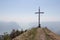 Colombina mountain peak with tourists, cross and blue sky on background