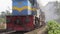 Colombo, Sri Lanka - January 12, 2018.Traditional Sri Lankan train with open doors and passengers on the footboard passes the stat