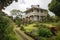 colonial house with wrap-around porch, offering a view of the garden