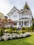 Colonial style white wooden cladding family house exterior. Beautiful front yard landscaping design