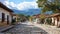 Colonial town street with cobblestone road and mountain backdrop