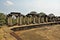 Colonnade at the top of the ancient temple. On the perimeter of a large stone platform, there are dilapidated columns