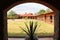 Colonnial farm and country house, stone and red brick construction with arches and green grass garden