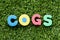 Color alphabet letter in word COGS Abbreviation of Cost of goods sold on green grass background