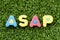 Color alphabet in word ASAP Abbreviation of as soon as possible on artificial green grass background