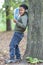 Color baby leaning against a tree reading a book