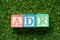 Color block in word ADR Abbreviation of adverse drug reaction on artificial green grass background