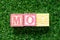 Color block in word MOQ Abbreviation of Minimum Order Quantity on artificial green grass background