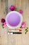 Color bowl with lilac paint on wood board, flowers