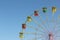 Color cabins of a ferris wheel against the blue sky