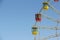 Color cabins of a ferris wheel against the blue sky