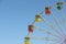 Color cabins of a ferris wheel against the blue sky