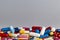 Color capsules and pills on grey background, top view copy space