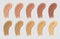 Color foundation smudges. Liquid beige and brown concealer tone strokes. Realistic cosmetic cream base swatches. Makeup