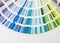 Color guide close up. Assortment of colors for design. Colors palette fan on white concrete wall background. Graphic designer