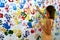 Color handprints on a white wall and young woman who makes them