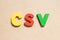 Color letter in word CSV Abbreviation of Computer system validation or Comma-separated values on wood background