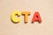 Color letter in word CTA Abbreviation of Call to action or Chartered tax adviser on wood background