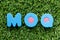 Color letter in word MOQ Abbreviation of Minimum Order Quantity on artificial green grass background