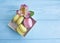 Color macaron gourmet biscuit in a box on a blue wooden background, confectionery alstroemeria flower