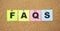 Color notes with letters pinned on a board. Word FAQS