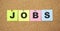 Color notes with letters pinned on a board. Word JOBS