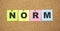 Color notes with letters pinned on a board. Word NORM