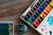 Color pencils, brushes and watercolor paints on wooden background. art painter accessories Flat lay