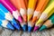 Color pencils pile in close up macro shot, wooden desk