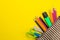 Color pencils in a school pencil case on a bright paper yellow background. Office tools. education. top view