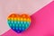 Color pop it antistress toy for children. rainbow heart shaped isolated on pink background . Pop it toy.Copy space