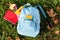 Color rucksack with school stationery on ground outdoors