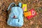 Color rucksack with school stationery on ground outdoors