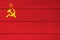 The color of Soviet Union flag painted on Fiber cement sheet wall background. a plain red flag with a golden hammer and sickle and