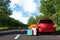 Color suitcases and inflatable ring near family car on highway