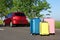 Color suitcases near family car on highway