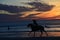 The color of sunrise envelopes a small group of horseback riders