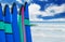Color surf boards in a stack by ocean