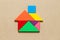 Color tangram in home or house shape on wood background