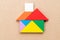 Color tangram in home shape on wood background