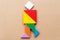 Color tangram in running or joy people shape on wood background