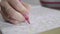 Color video of a woman hand holding a pencil drawing and coloring coloring book. Activity for relaxing and concentrate