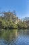 Colorado River with trees and luxury apartments exterior against blue sky