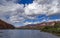 Colorado river with vibrant red rock cliffs and clouds