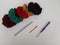 Colored balls of crochet thread, scissors and a needle on a white background
