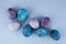 Colored blue and violet Easter eggs on the light-blue paper back