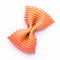 Colored bow tie pasta. Closeup single orange farfalle on white background